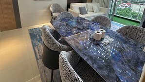 A modern dining area with a marble table, wicker chairs, and a chandelier. - Spacious & High-Floor Hotel near City of Dreams, Airport, Okada, and Solaire Casino (Parañaque)