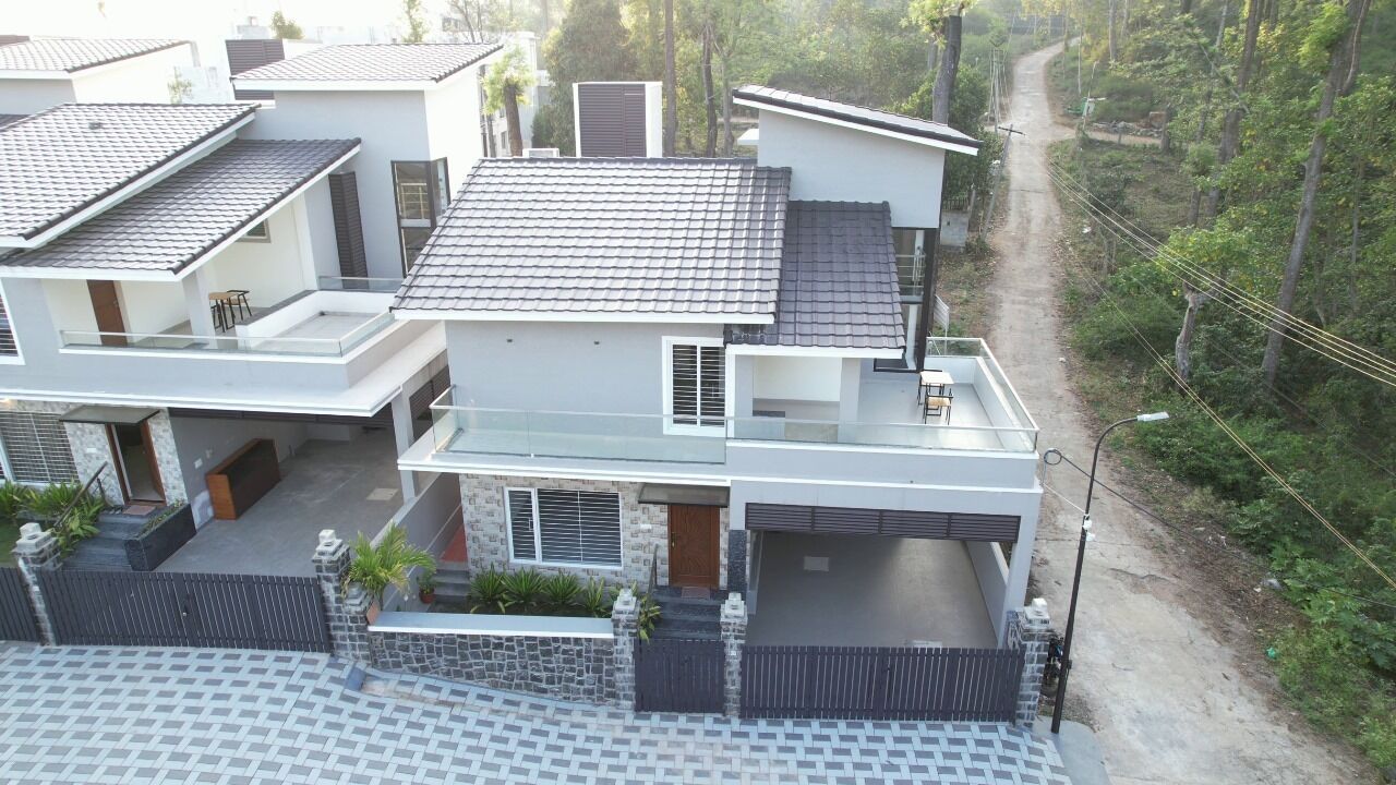 Una moderna casa a due piani con garage, balcone e vialetto pavimentato.
