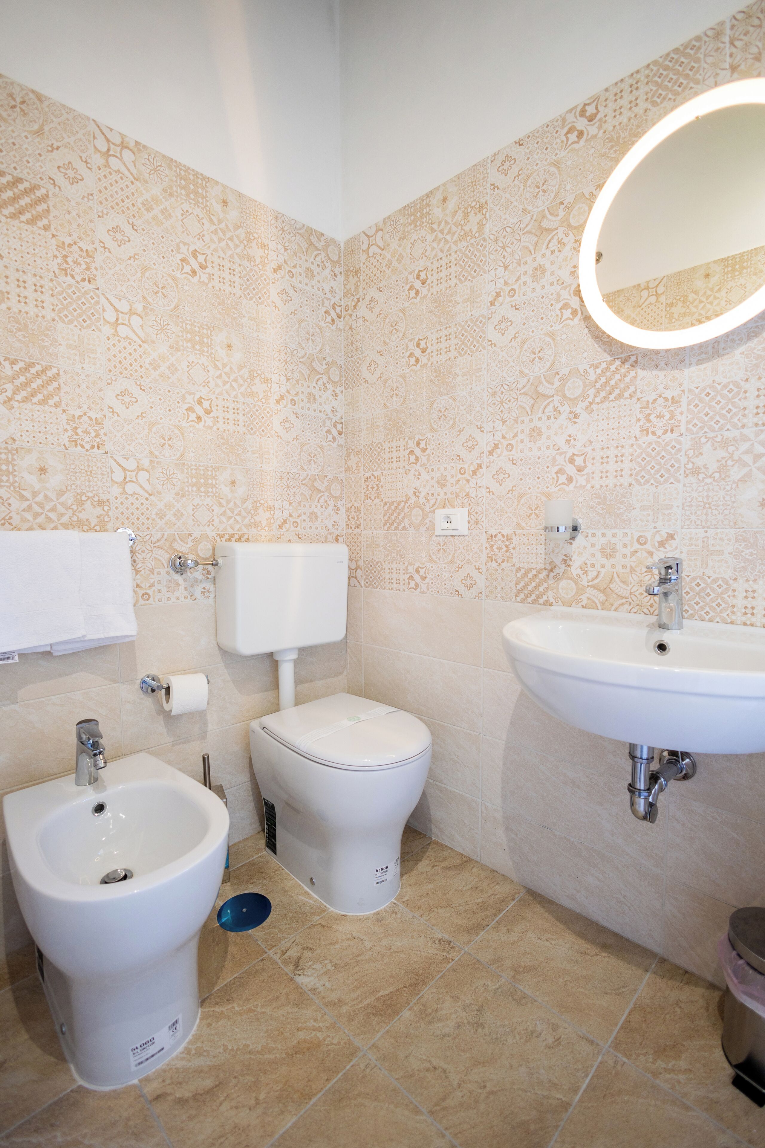 Ein Badezimmer mit einer Bidet-Einrichtung, Toilette und Waschbecken.