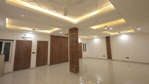 A spacious hotel room with a high ceiling, recessed lighting, and a polished floor. - PriyaKunj Dham Guest House (Mathura)