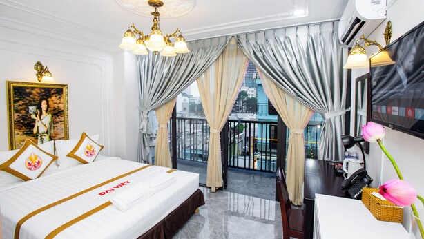 Habitación de hotel con cama, escritorio y vista a la ciudad.