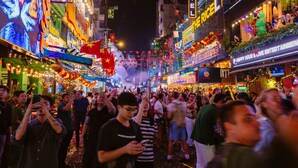 Una calle concurrida, luces de neón y una multitud de gente.