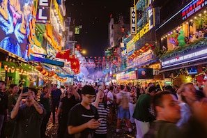 A busy street with neon signs and a crowd of people. - The Rice Hotel & Tour - 180 Bui Vien (Ho Chi Minh City)
