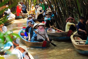 Un grupo de personas en barcas tradicionales en un río.