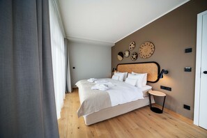 A modern bedroom with a large bed, bedside table, and decorative wall art.
