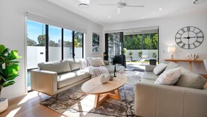 A modern living room with two sofas, a coffee table, and a large window.