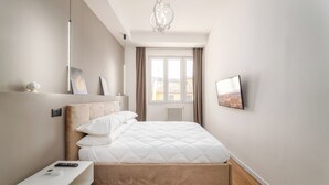 A modern bedroom with a bed, bedside table, and a mounted TV.