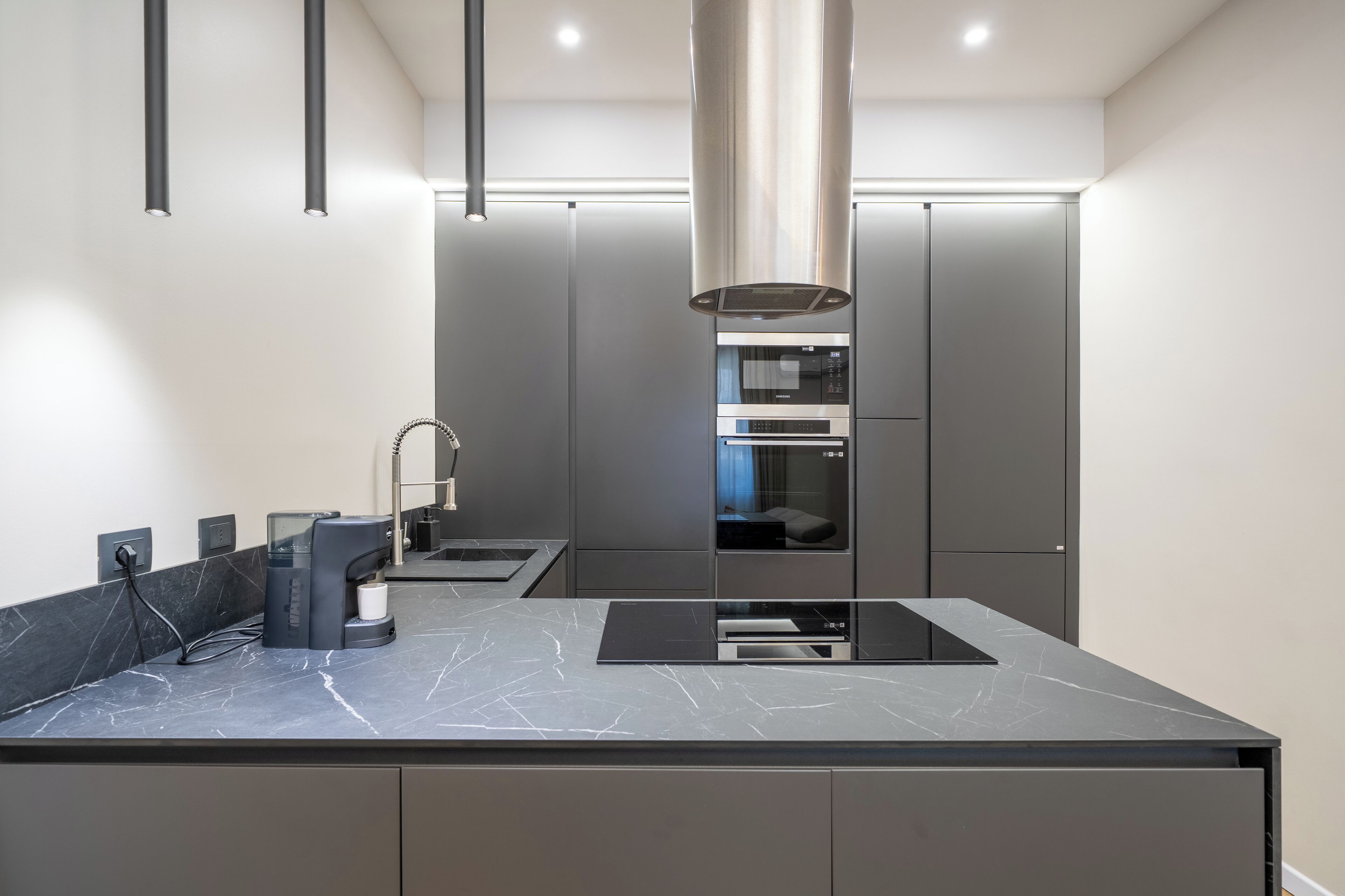 A modern kitchen with a large island, built-in appliances, and a sleek design.