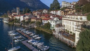 A coastal town with buildings along a waterfront, a dock with boats, and a mountain in the background. - Villa Silva wiht pool - My Rental Homes (Torno)
