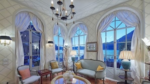 A spacious room with large windows, elegant furniture, and a chandelier. - Villa Silva wiht pool - My Rental Homes (Torno)