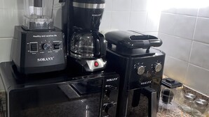 A kitchen with a blender, coffee maker, and toaster on a granite countertop.