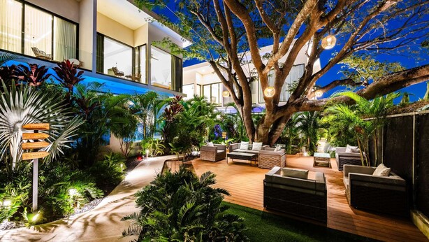 A modern outdoor lounge area with a large tree, seating arrangements, and a pathway. - Maitri ❤️ 2 BR | 3 BA | Private Pool | Villa | Fast Wifi (Tamarindo)