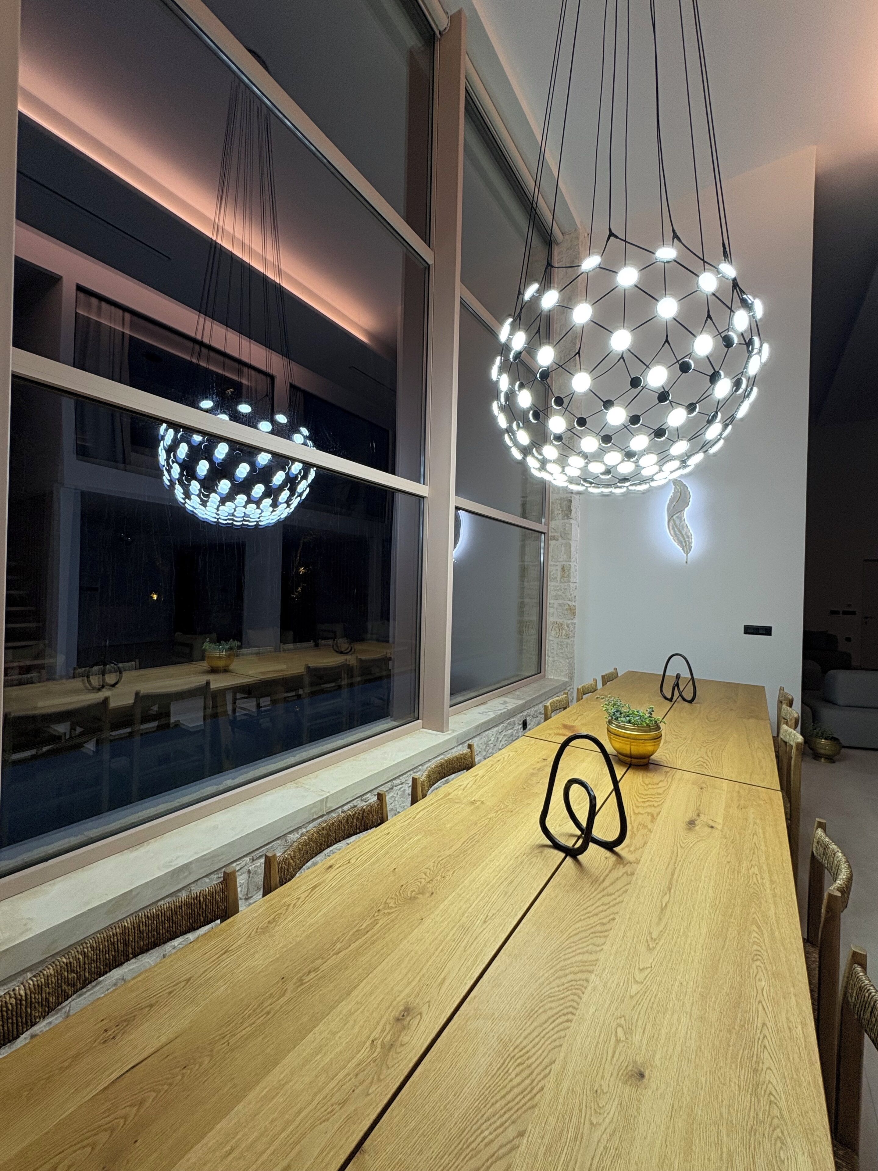 A dining area with a wooden table, chairs, and a large window.
