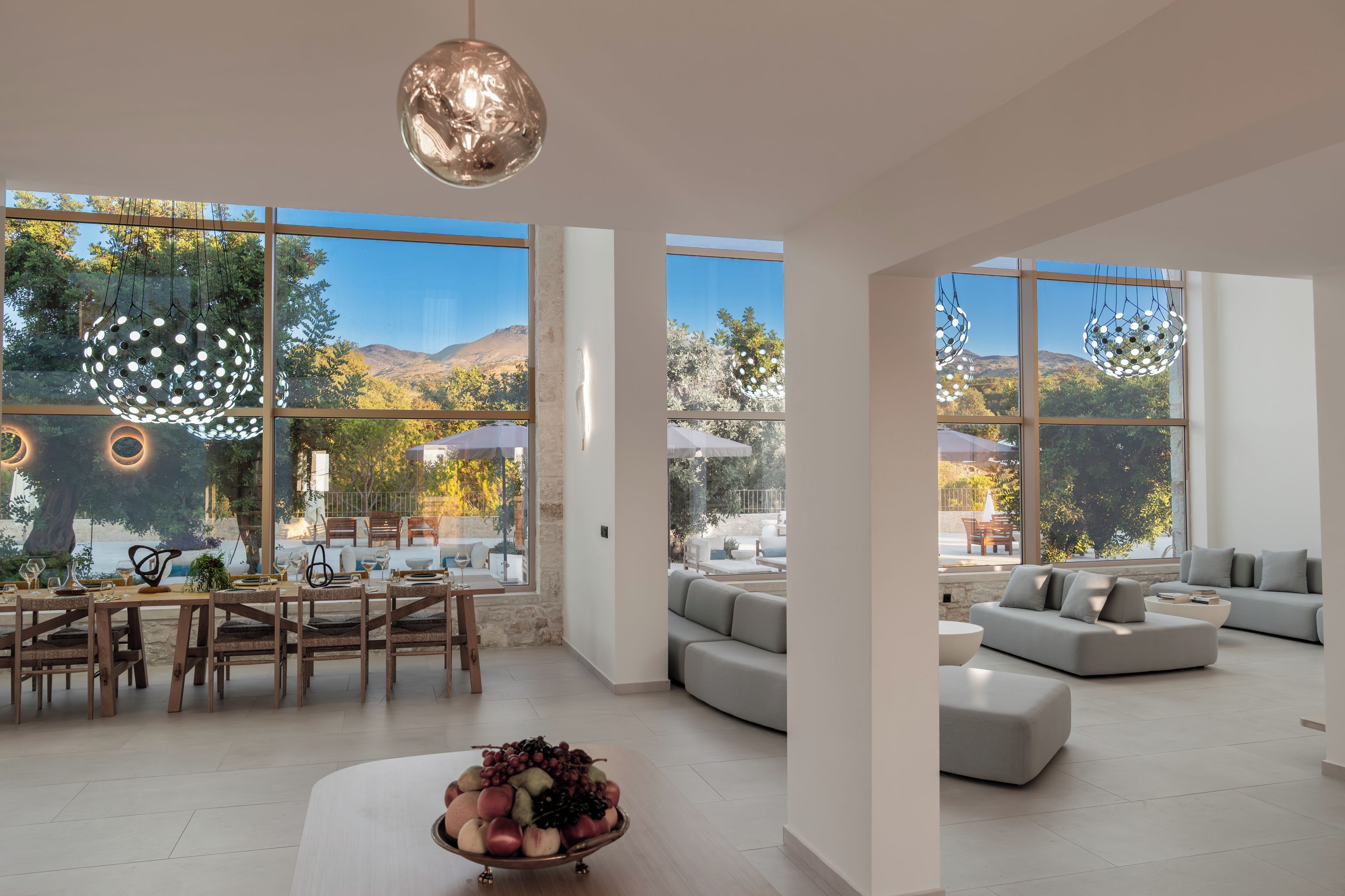 A spacious living area with a dining setup and a large window offering a view of a mountainous landscape.