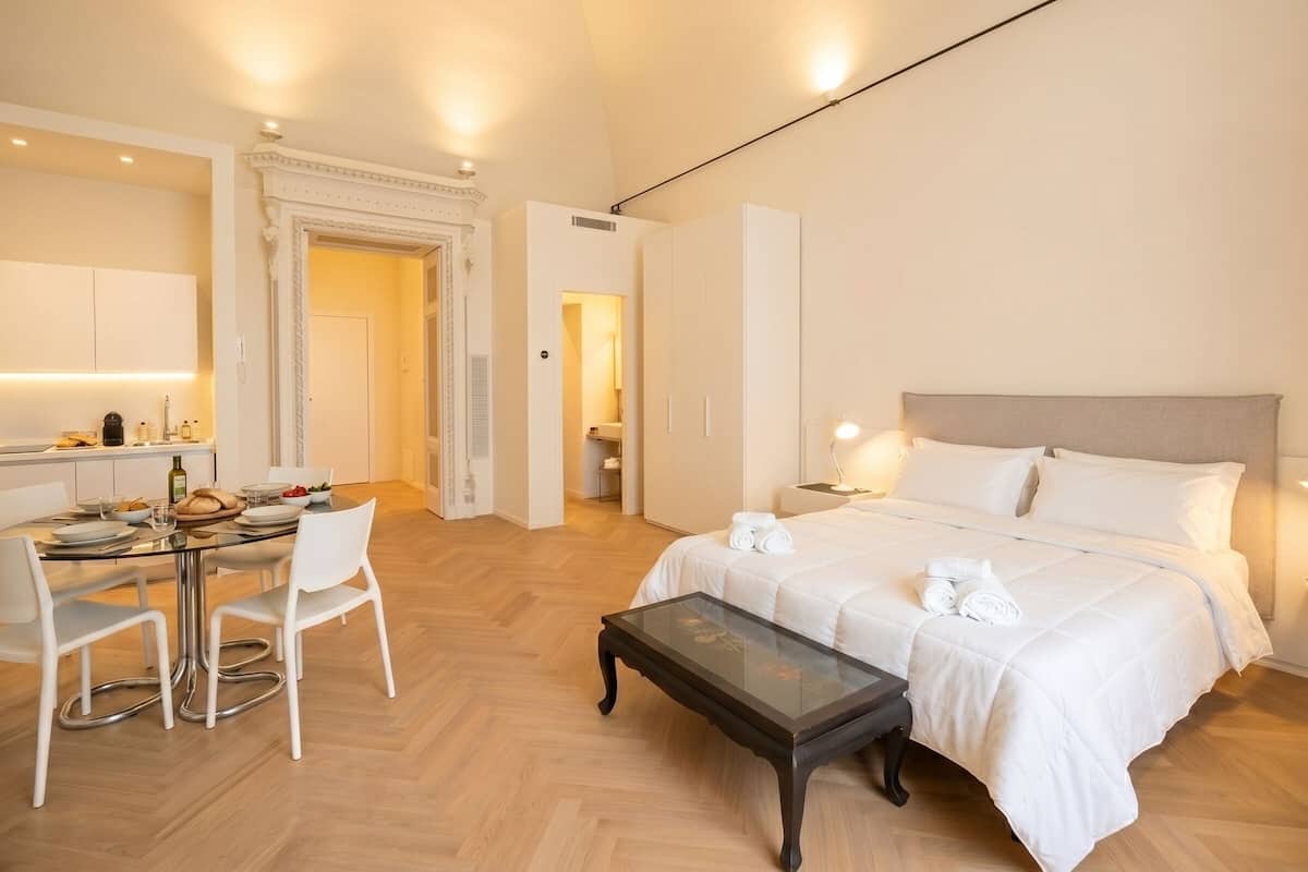 Une chambre d’hôtel comprenant un lit, une table de chevet et un coin repas avec des chaises et une table.