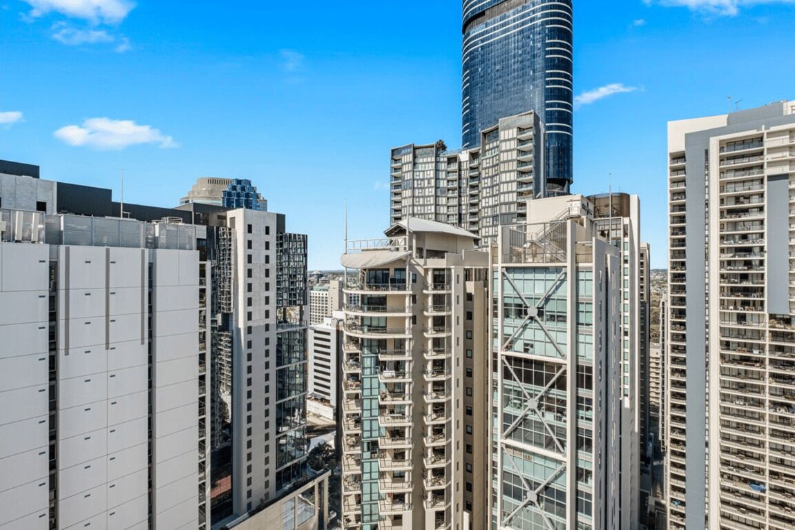 A high-rise urban area with modern buildings, including a prominent cylindrical skyscraper and several residential high-rises.
