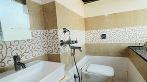 A small, compact bathroom with a white sink, a toilet, and a shower. - artus inn midc andheri east mumbai (Mumbai)