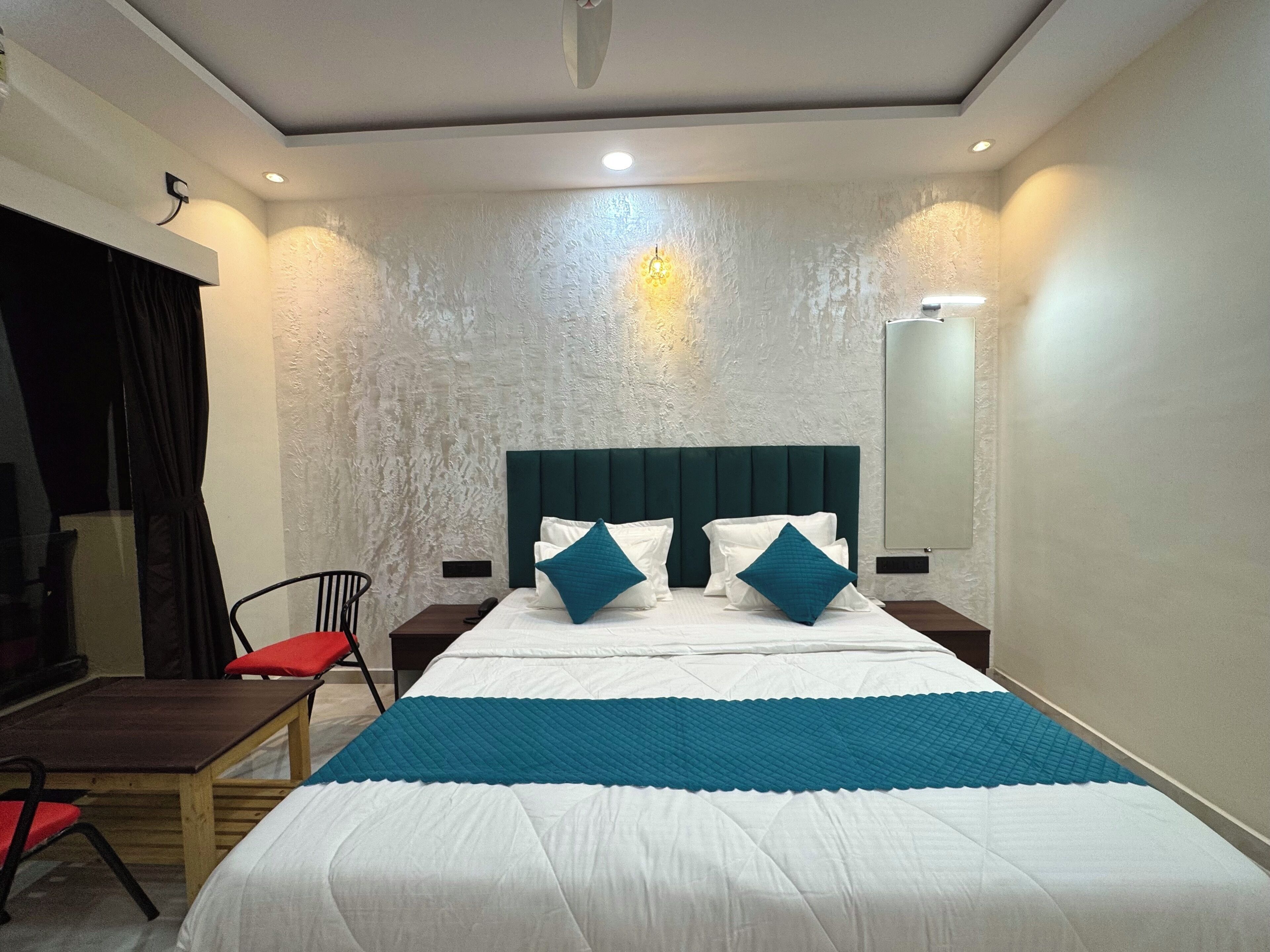 A hotel room with a large bed, a desk, and a chair.