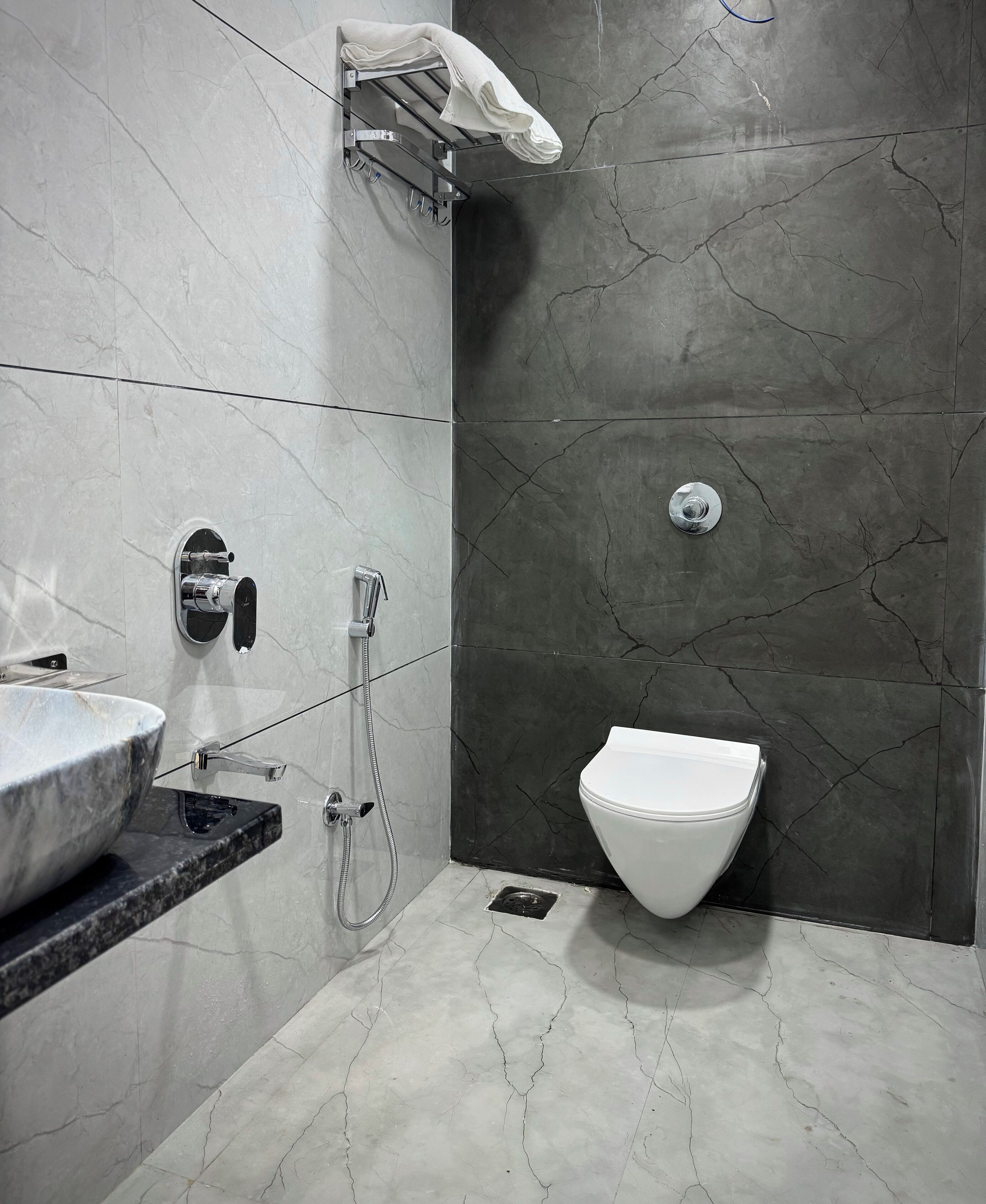 A modern bathroom with a marble sink, a toilet, and a shower area.