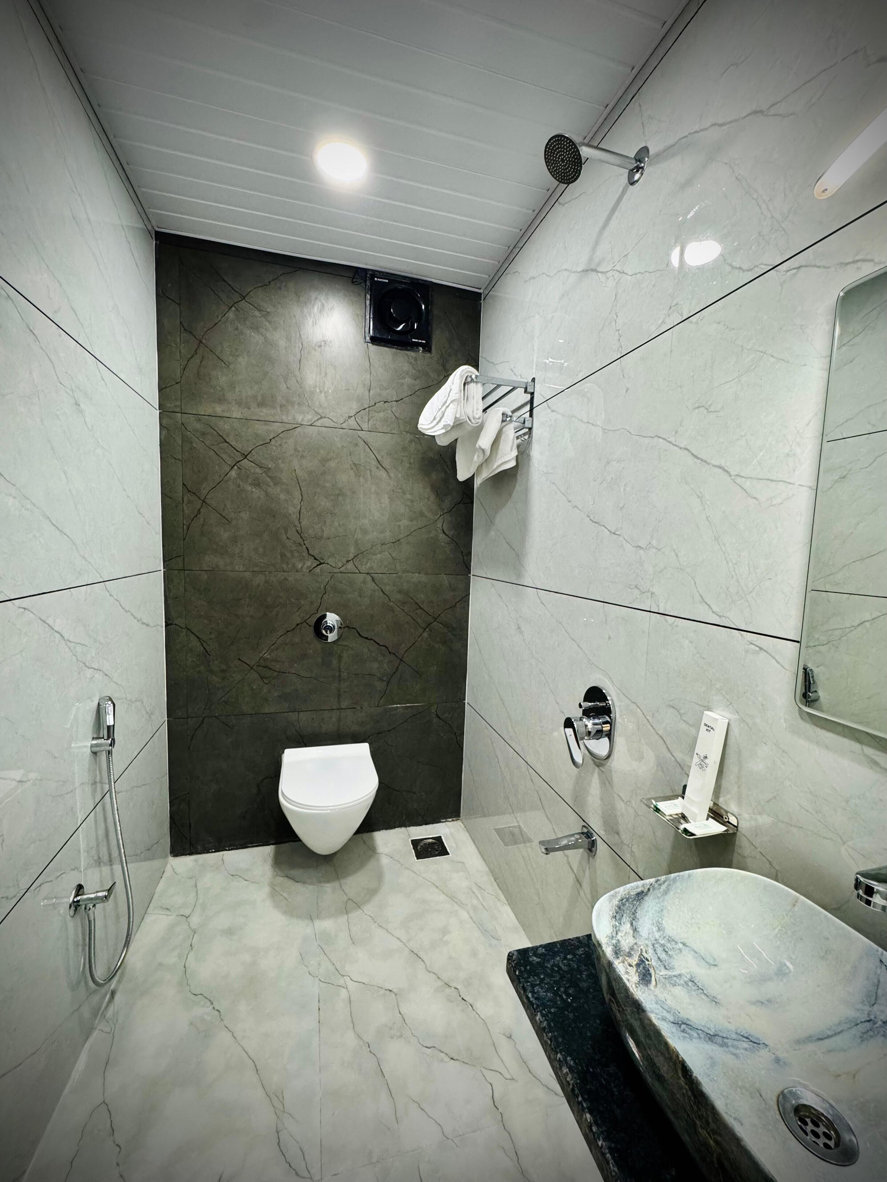 A modern bathroom with a toilet, sink, and shower.