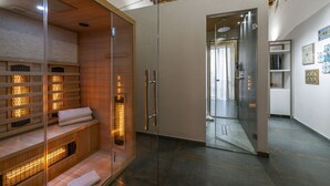 A modern spa room with a glass enclosure, wooden benches, and a visible shower area. - Ballarooms Experience (Palermo)