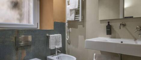 A modern bathroom with a toilet, bidet, and sink.