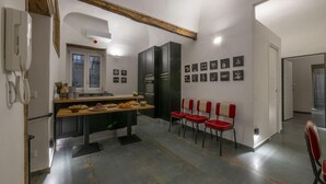 A modern kitchen with a dining area, featuring a wooden table, chairs, and a refrigerator. - Ballarooms Experience (Palermo)