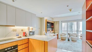 A modern kitchen with a central island, built-in oven, and a dining area with a view of the city.