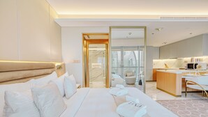 A hotel room with a large bed, a desk, and a view of the city.