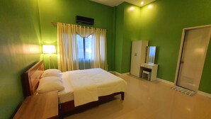 A hotel room with a bed, bedside table, lamp, wardrobe, and a mirror. - Enjoyable 4-bedroom house with AC in Panglao (Panglao)