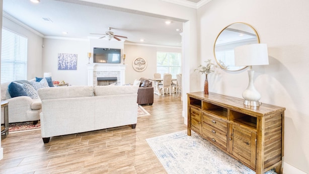 A spacious living room with a large sofa, wooden entertainment center, and a fireplace.