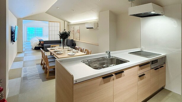 A modern kitchen with a central island, built-in appliances, and a dining area with a view to the outside.