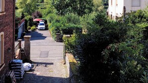 A narrow cobblestone street flanked by buildings, leading to a hill with dense greenery. - Vacation apartment "Beim alten Pfarrhaus" (Zell (Mosel))