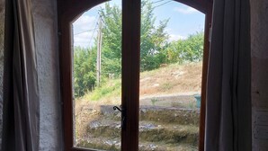 A wooden door with a glass panel, curtains, and a rug on a tiled floor.