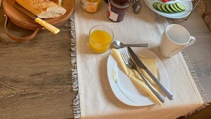 A breakfast setting with croissants, cheese, grapes, and a croissant plate.