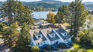 A two-story house with a large front porch, a garage, and a backyard with a small deck.