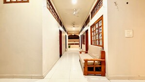 Ein Korridor mit einer Bank, Deckenventilatoren und einem gefliesten Boden.