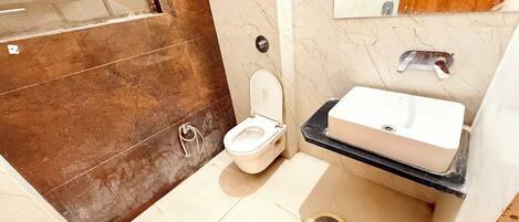 Ein Badezimmer mit Toilette, Waschbecken und Duschbereich.