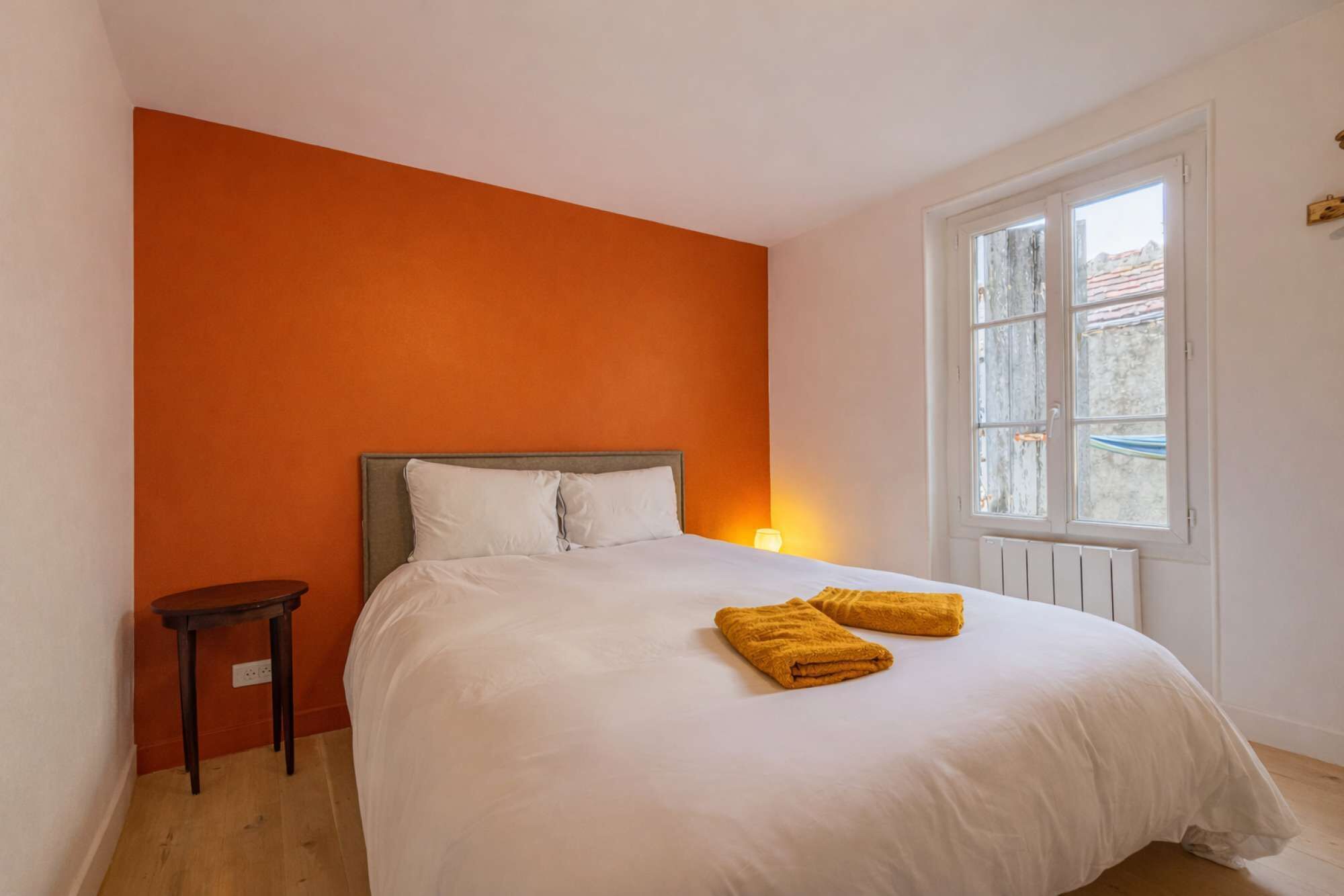 Ein Schlafzimmer mit einem Bett, einem Nachttisch und einem Fenster.