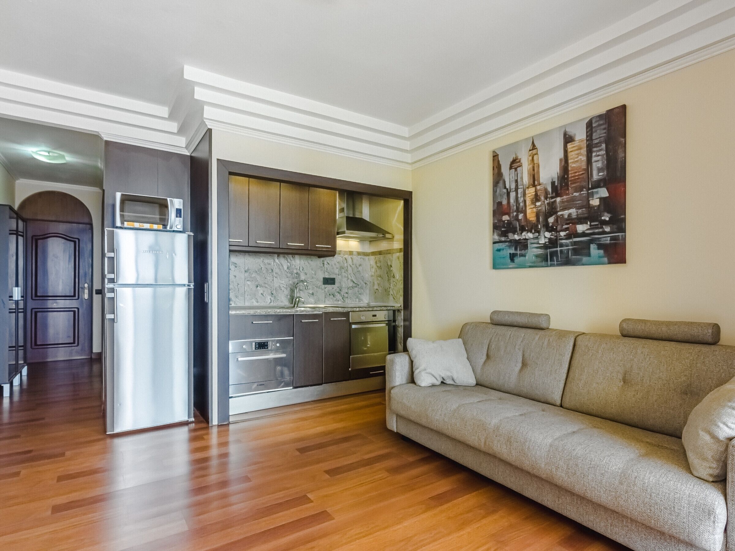 A modern kitchen with built-in appliances, a marble backsplash, and a dining area.