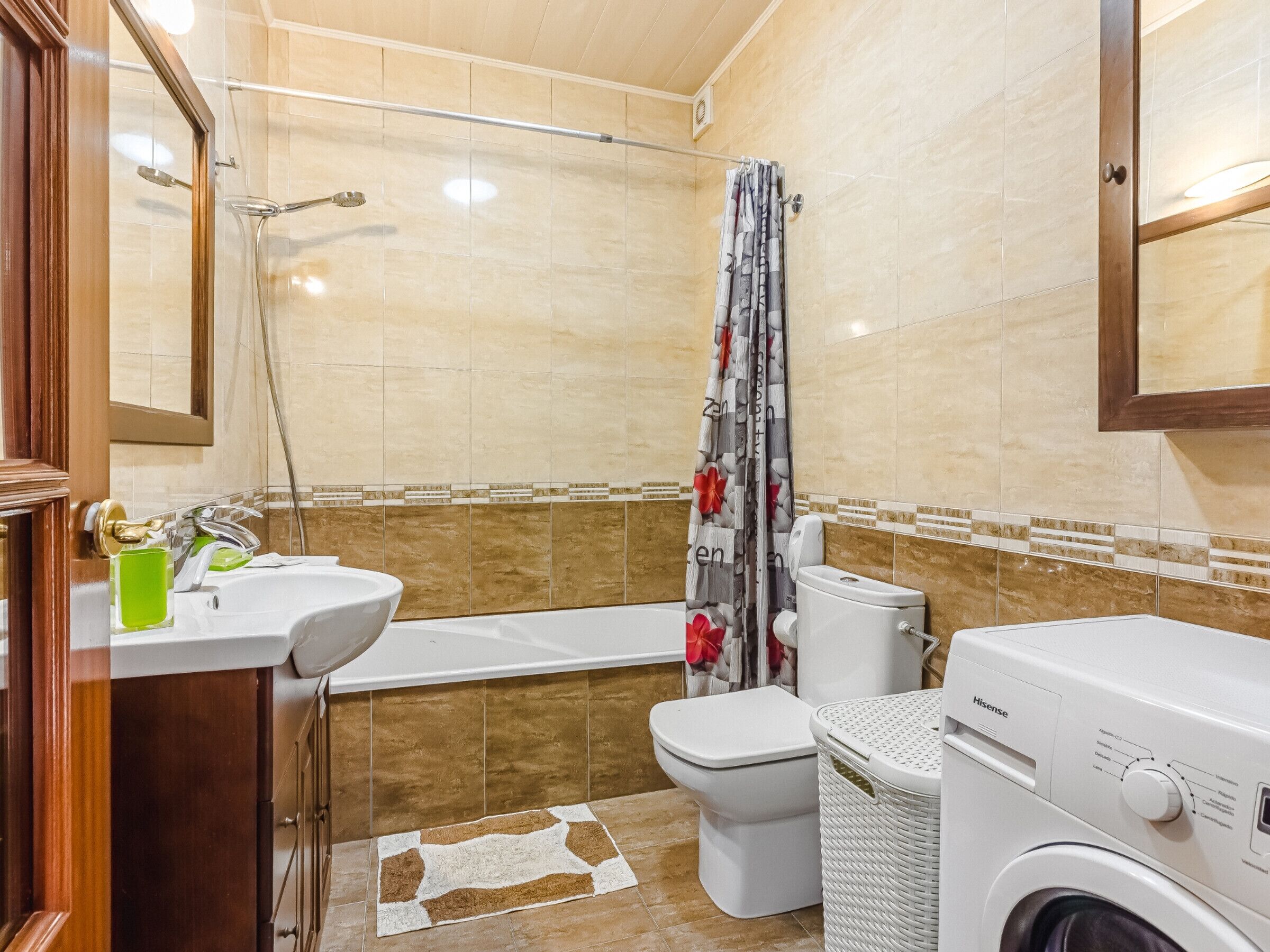 A bathroom with a bathtub, toilet, and washing machine.