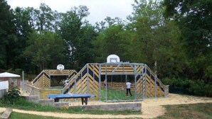 A sports court with a basketball hoop and a tennis court.