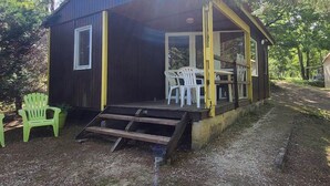A small cabin with a porch, a table, and two chairs.