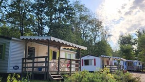Une rangée de maisons mobiles, chacune dotée d’une véranda et d’un petit escalier menant à l’entrée.