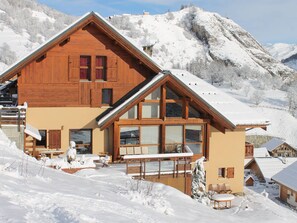 A wooden chalet with a sloped roof, large windows, and a balcony. - Duplex in Valloire: 4 rooms, 8 people, pets allowed, private parking (Valloire)