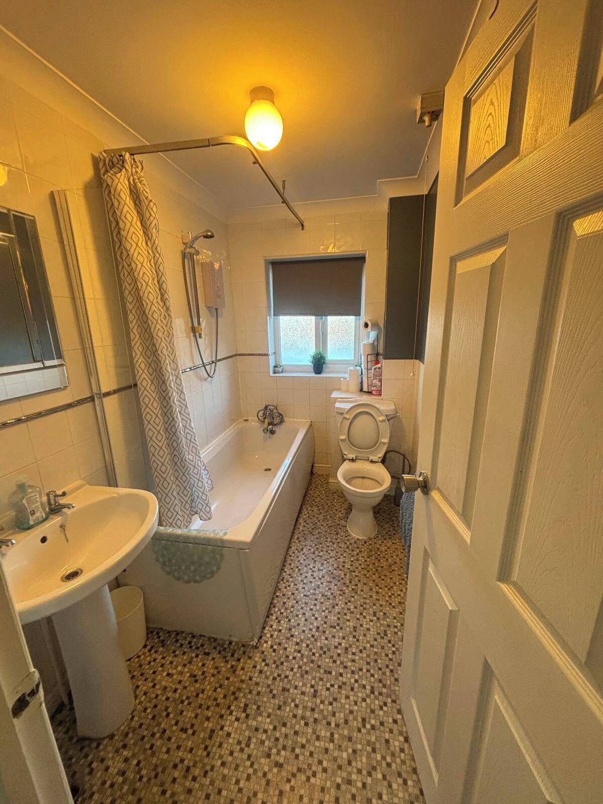 A bathroom with a bathtub, toilet, and sink.