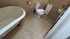 A small bathroom with a bathtub, toilet, and a radiator. - 2 Bed Apartment - Sleeps 4 - Parking - Wifi (Doncaster)