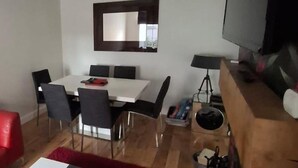 A modern living room with a dining area, a flat-screen TV, and a red rug. - 2 Bed Apartment - Sleeps 4 - Parking - Wifi (Doncaster)