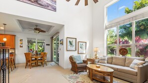 A spacious living area with a large window, a ceiling fan, a dining table with chairs, and a sofa. - 🌴 Hale Nanea | Bicycles Included | AC | Lagoon Style Pool Relax | Unwind & Recharge 🌴 (Kamuela)