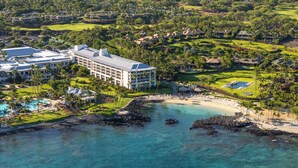 Ein Resort mit mehreren Gebäuden, einem Strand und einem Golfplatz.